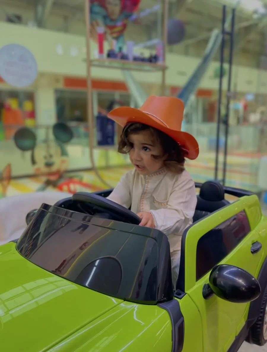 Kovboy şapkasıyla arabalı koltukta oyun